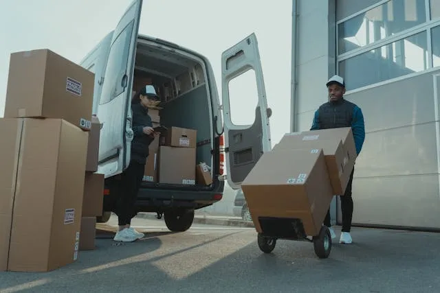 Freight and logistics invoice templates: a courier loading boxes into a delivery van
